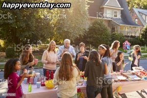 Neighbours talk and eat around a table at a block party